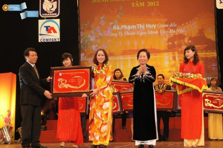 Bà Phạm Thị Huy - Giám đốc Công ty TNHH Thiên Ngọc Minh Uy nhận bảng vàng chữ Tâm do Phó chủ tịch nước Nguyễn Thị Doan trao tặng